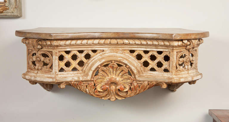 A pair of French mid. to late 19th century carved painted and parcel gilt wall consoles or brackets