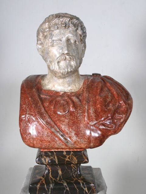 A late 19th-early 20th century carved faux painted bust of a Roman Emperor.