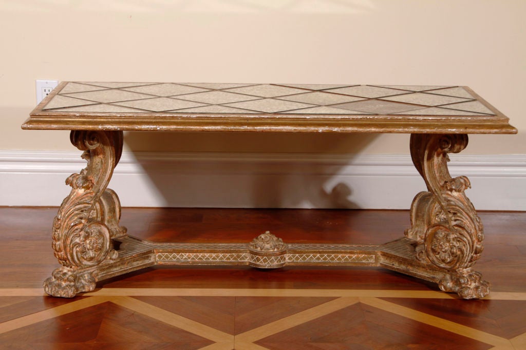 An Italian carved gilt coffee table with a divided distressed mirror top.