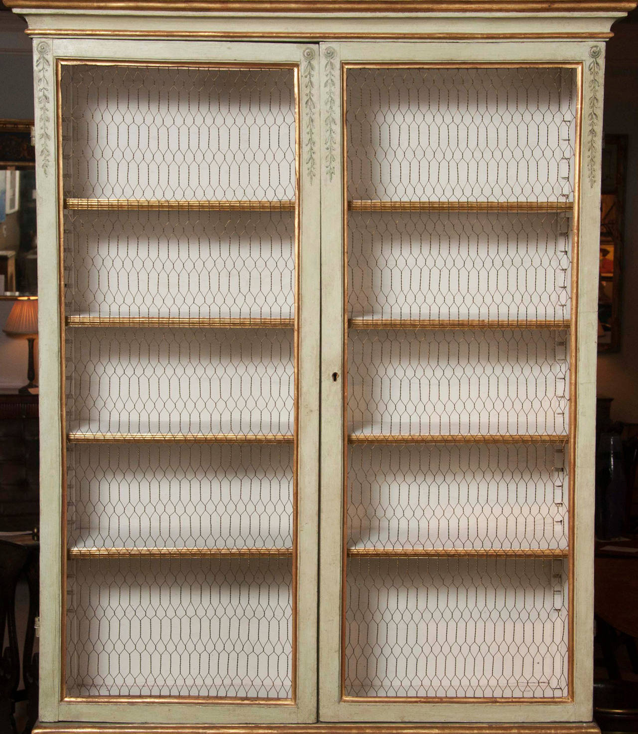 An Italian early 19th century painted neoclassical style cabinet decorated with urns, ribbons and garlands.