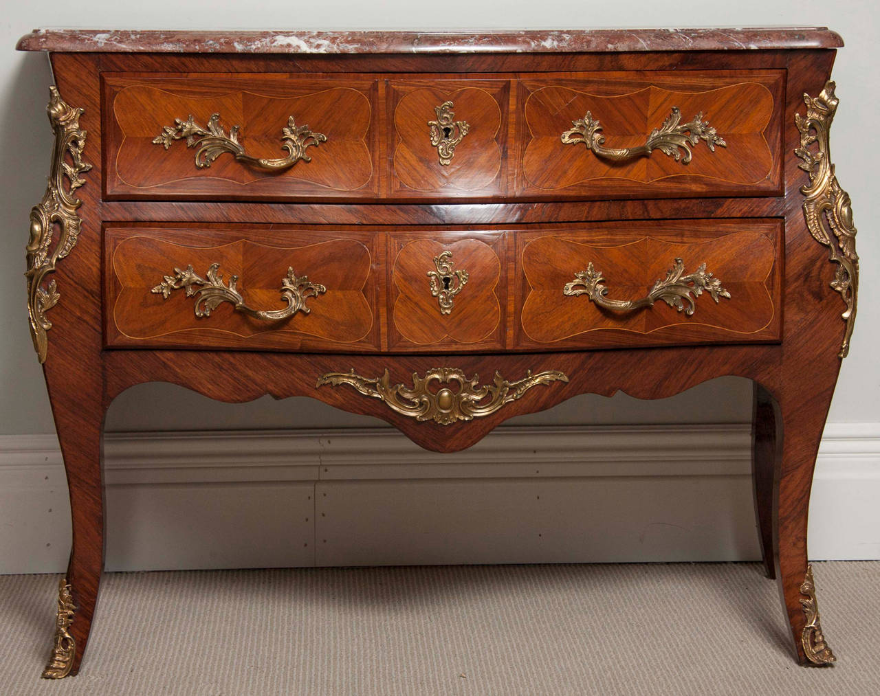 A French mid-19th century two-drawer tulipwood Serpentine commode with boxwood line inlay, rosewood crossbanding and ormolu mounts. Superb form and lighter and more elegant than the three-drawer model most commonly found in French furniture.
