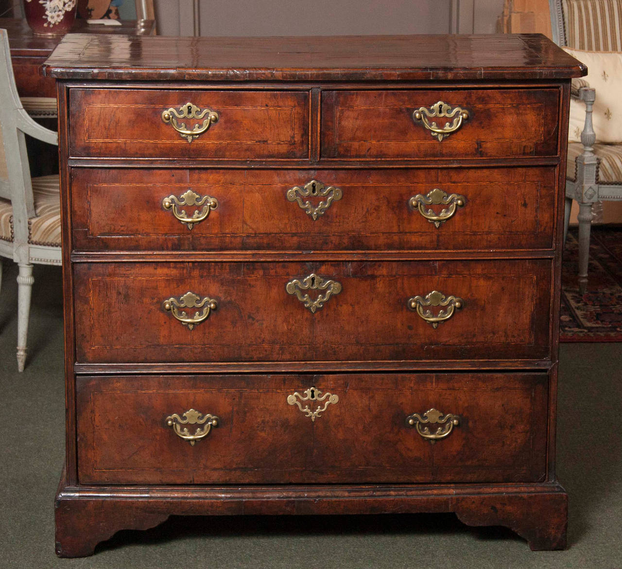 An English early 18th century George I walnut chest of drawers with excellent colour and patination; retaining it's original period brass hardware.