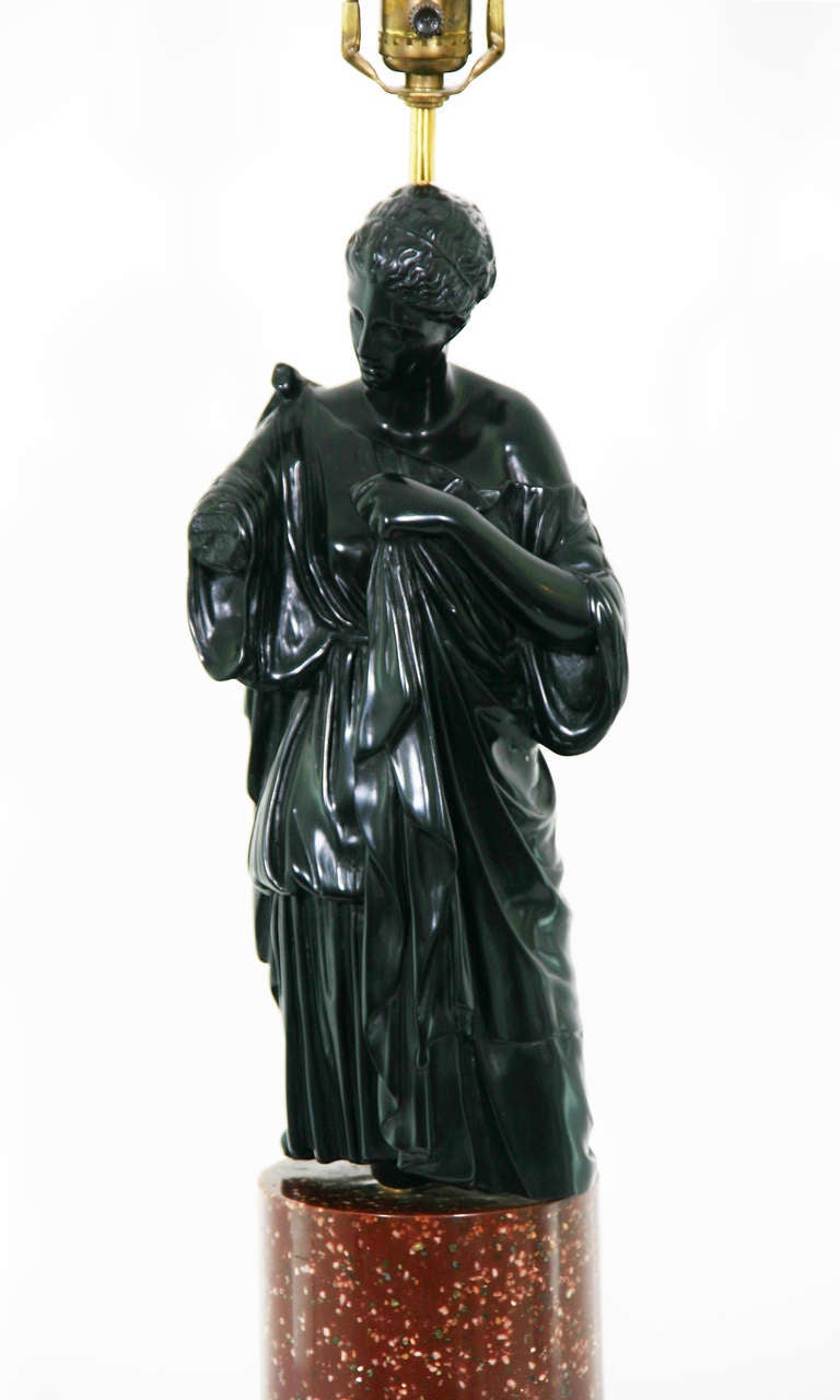 An Italian figure of a draped Goddess on a red porphery marble base; now as a lamp.