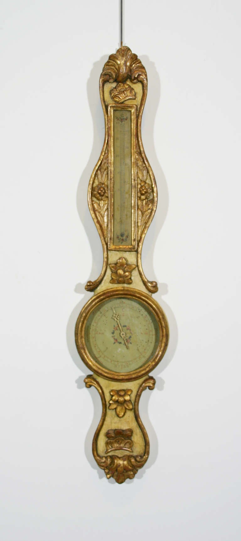 A French mid-18th century painted and parcel-gilt barometer with delicate floral carving.