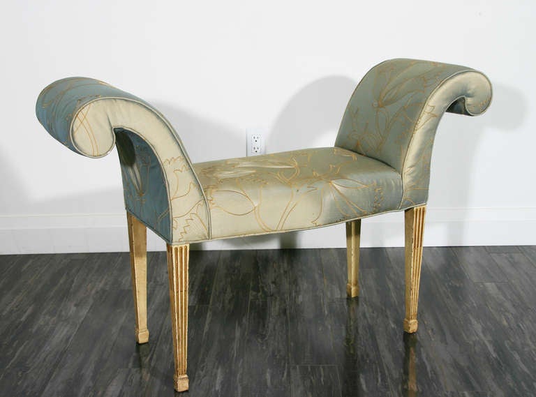 A Late 18th century neoclassical window/hall seat; the scrolling upholstered arms above a serpentine seat, raised on painted, parcel-gilt and stop fluted square tapering legs.