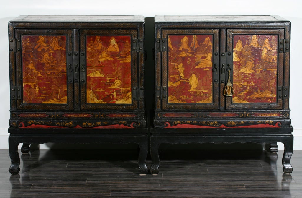 A pair of Chinese late 18th century red and black Chinoiserie decorated cabinets on later stands.
