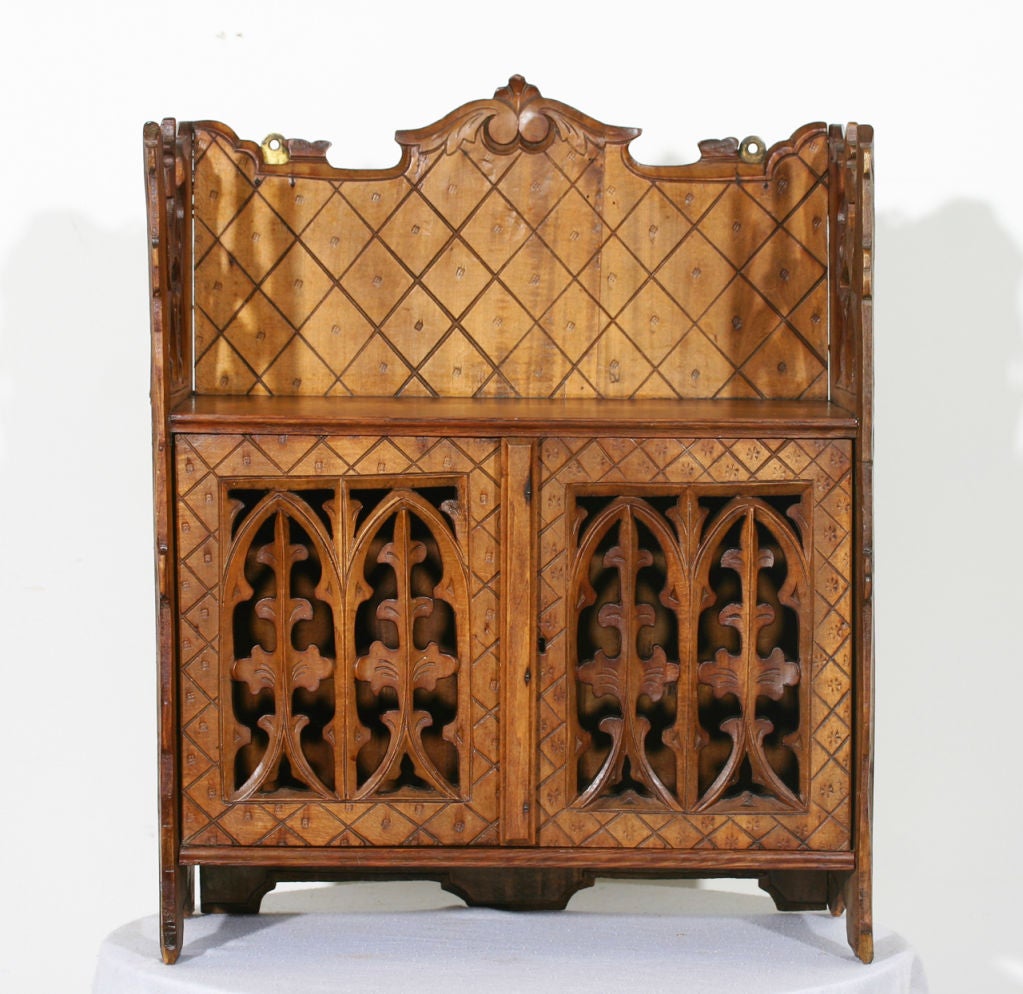 An English mid-19th century pine hanging wall cabinet in the Gothic style.