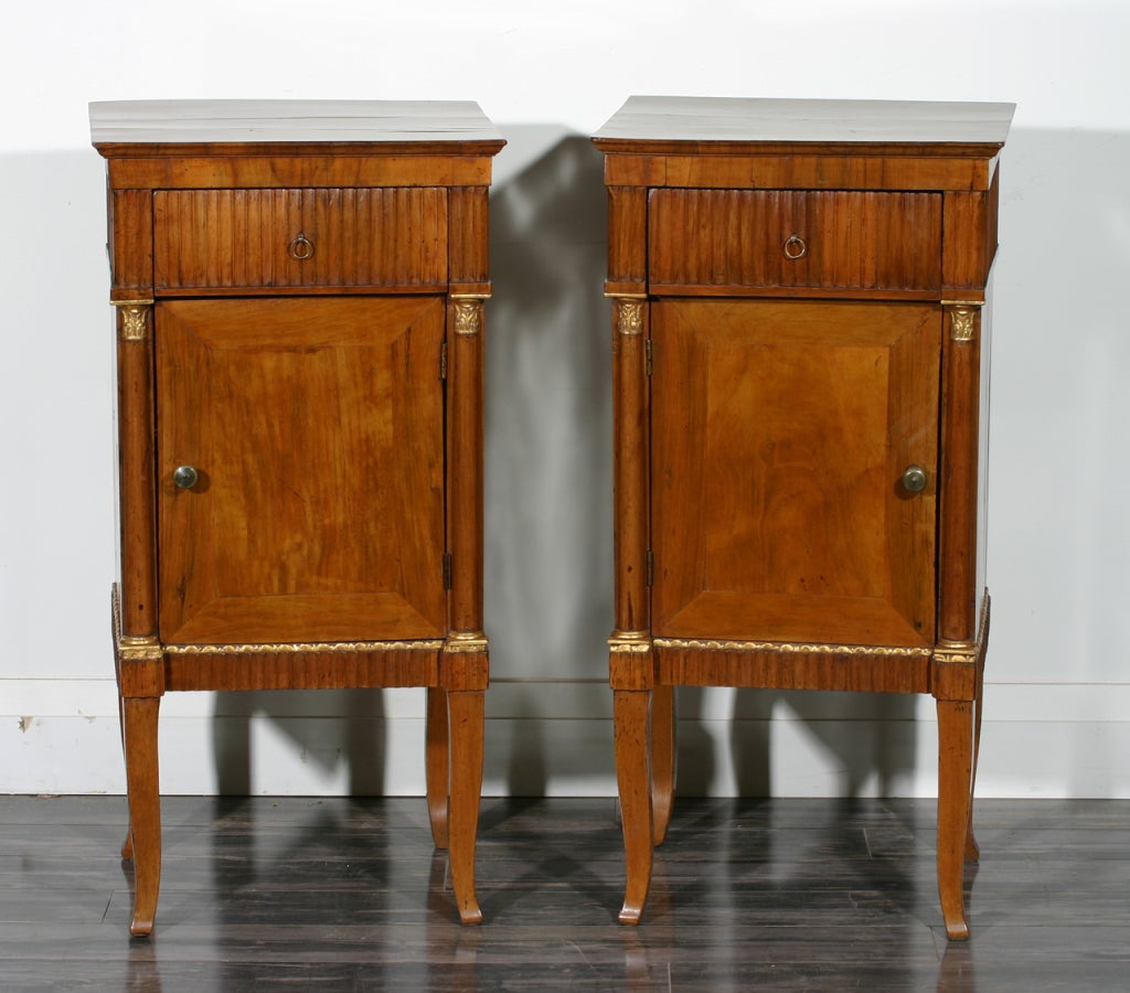 A pair of Italian early 19th century fruitwood and parcel-gilt nightstands.