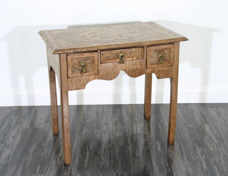 An English mid-18th century walnut lowboy with a marquetry inlaid top and shaped apron.
