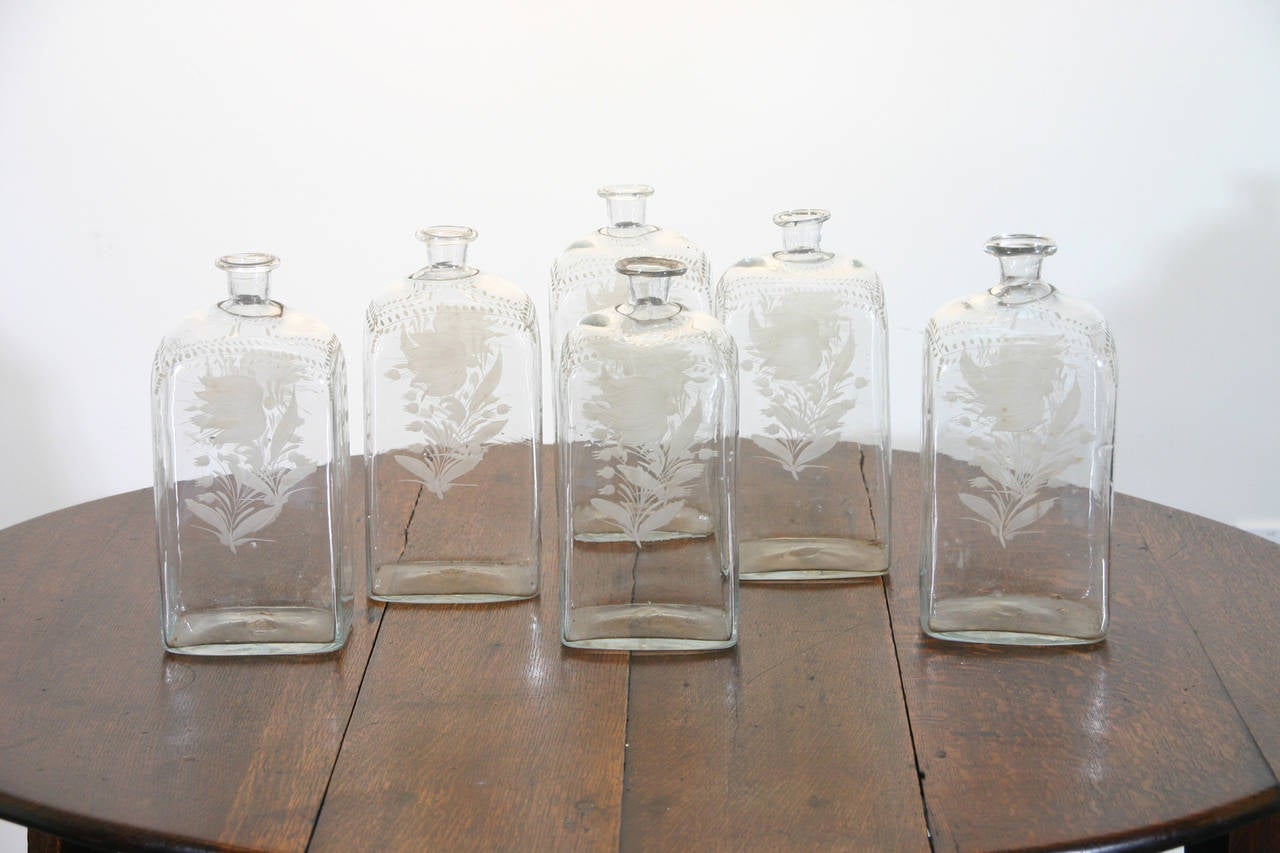 Six large and six smaller English 18th century engraved glass bottles.

Smaller bottles: 5 3/4
