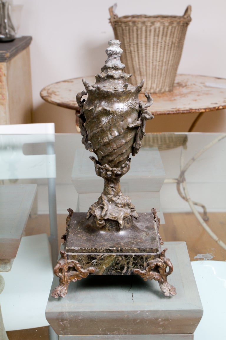 Pair of metal Victorian shell form urns on verde antico marble bases.