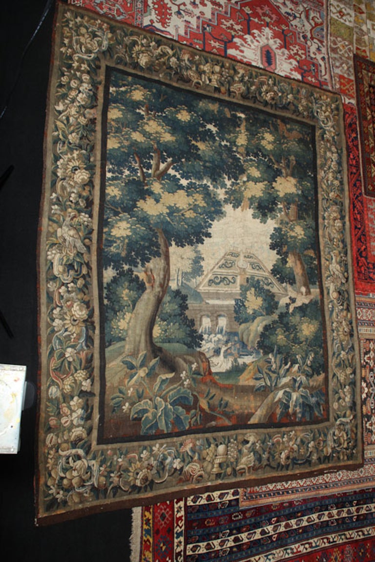 Lovely 17th Century Flemish verdure tapestry, featuring a fountain and water park with estate in the background, water flowing under bridge framed by trees with birds and flowers in the foreground, the border wrought with foliate, fruit and bird