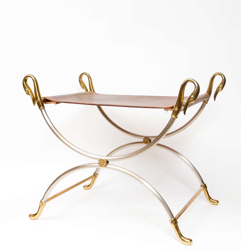 Stylish polished steel and brass curule stool with cast swans neck detail and leather seat.
