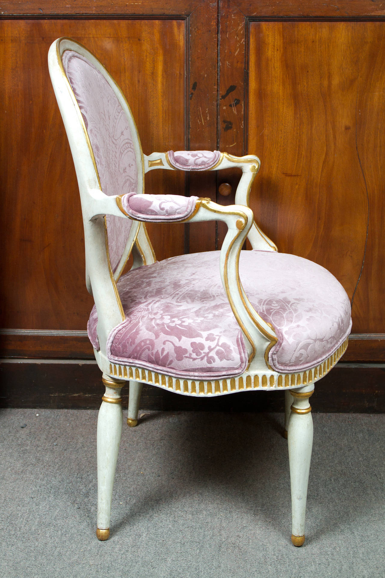 Pair of Italian white painted and parcel-gilt neoclassical style armchairs upholstered in stamped damask style textured mauve velvet.