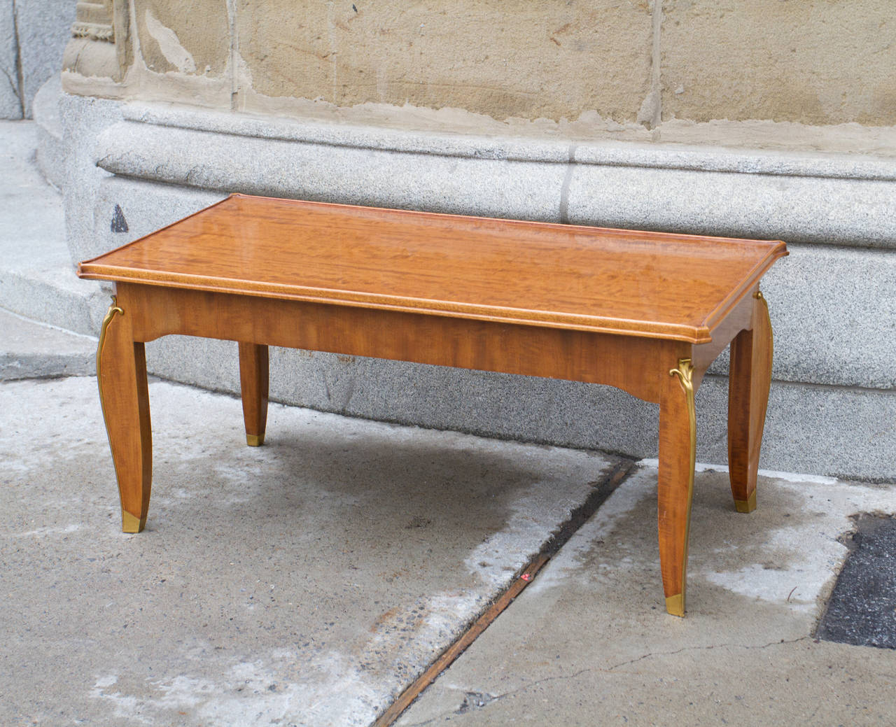 Stylish mahogany coffee table by Jules Leleu, beautifully fitted with gilt bronze. This piece is part of a suite of furniture bought in Paris in 1953.