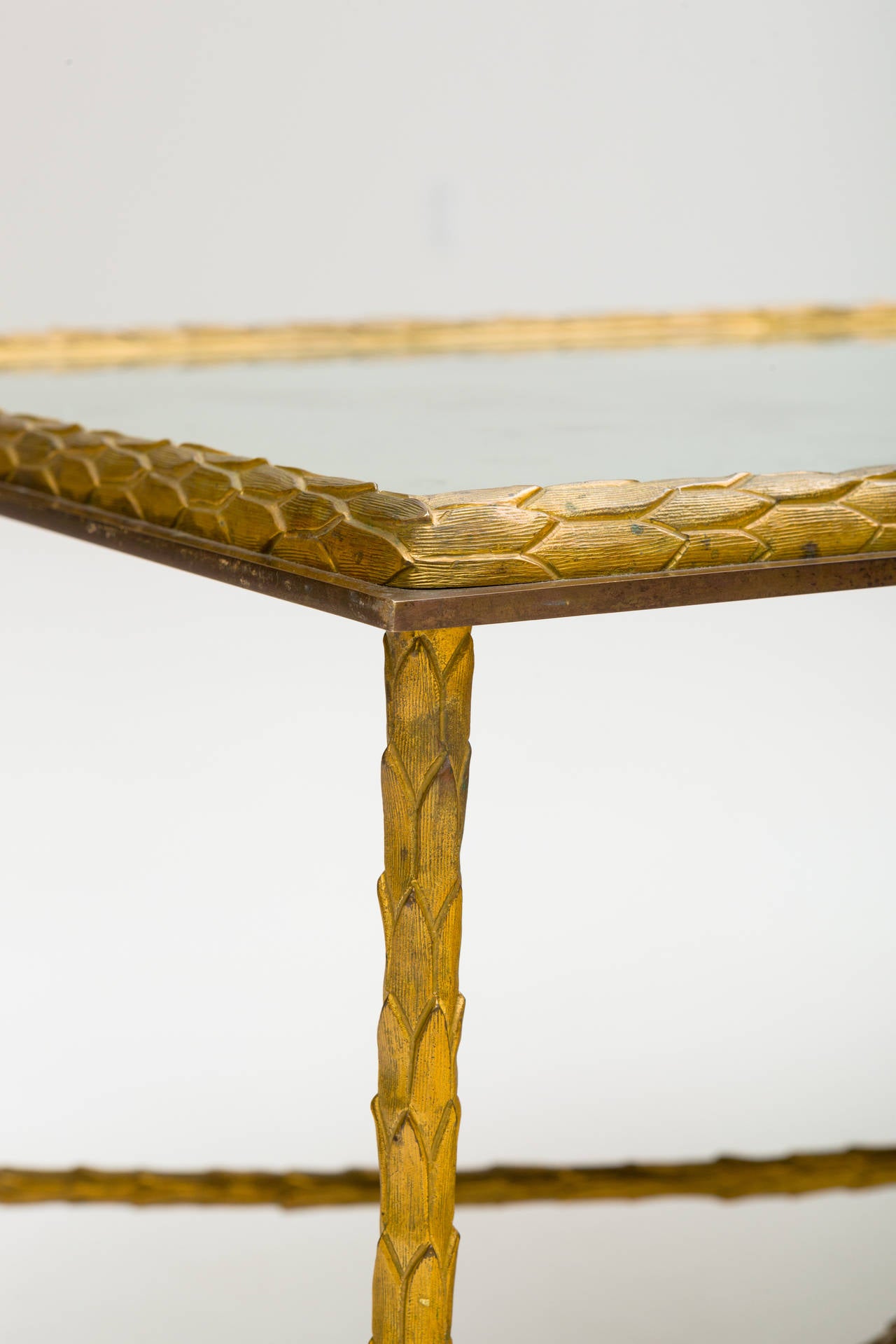 Elegant gilt bronze coffee table by Maison Bagues with patinated mirrored glass top.