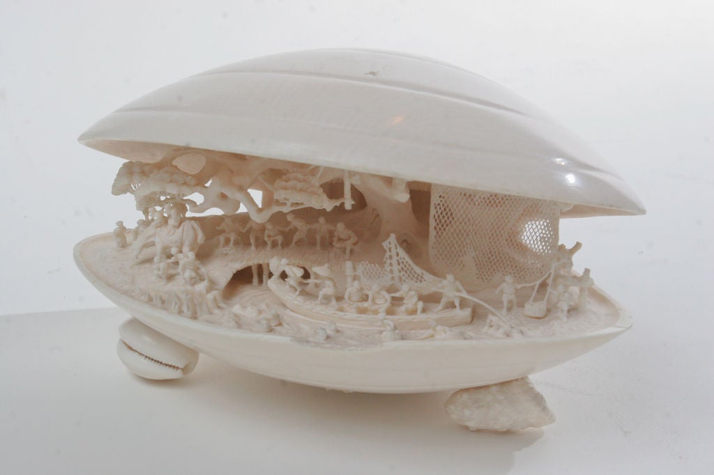 Fine intricately carved ivory miniature fishing scene set inside an open shell. All carved from one pice of ivory.