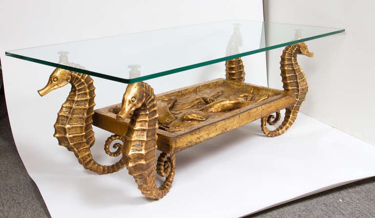 Unusual gilt metal terracotta sculptural coffee table in the form of four seahorses centered by a gilt relief carving of Triton.