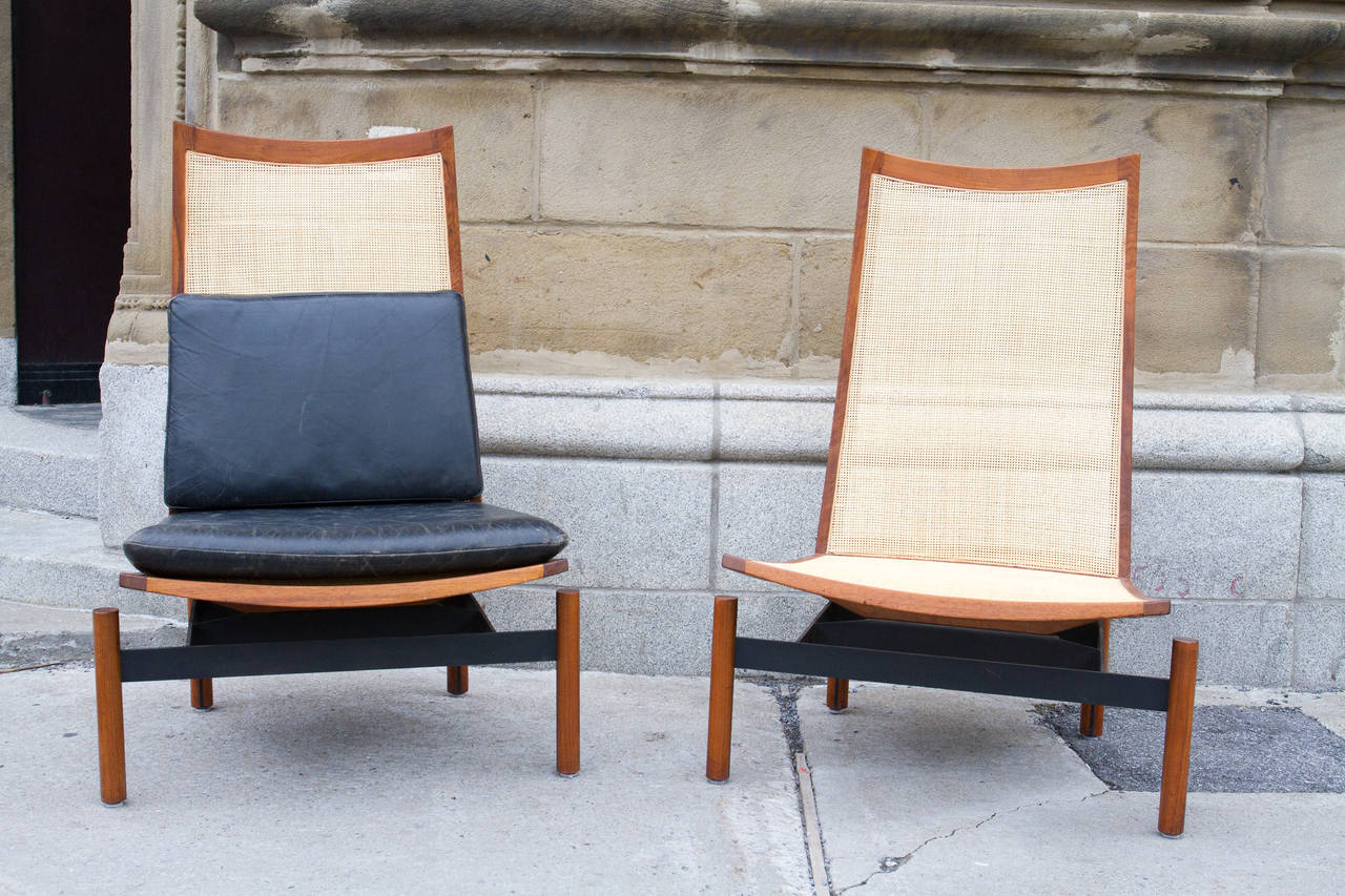 Impressive pair of Midcentury walnut and steel caned-back lounge chairs with detachable leather seat cushions.