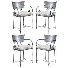 Juego de cuatro sillones de acero pulido