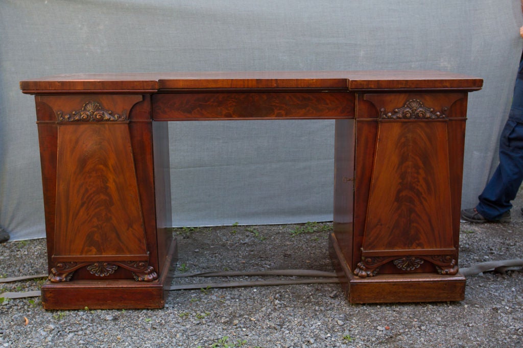 William IV period figured mahogany pedestal sideboard decorated with neoclassical relief carvings.