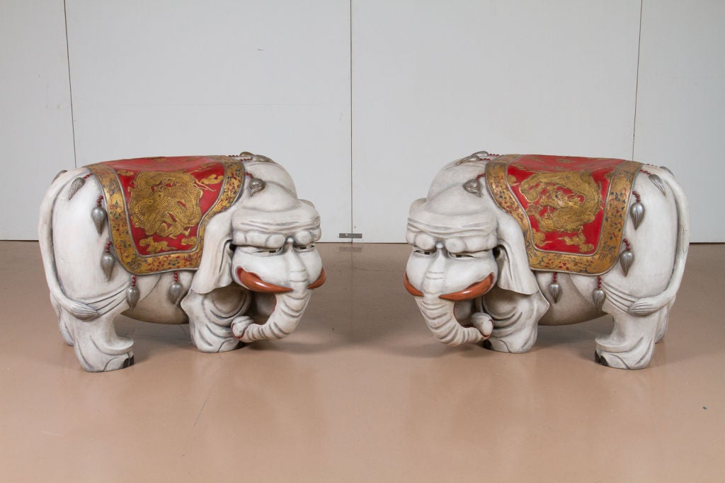 Whimsical pair of painted and gilt, Chinese carved wood elephant benches fitted with glass eyes.