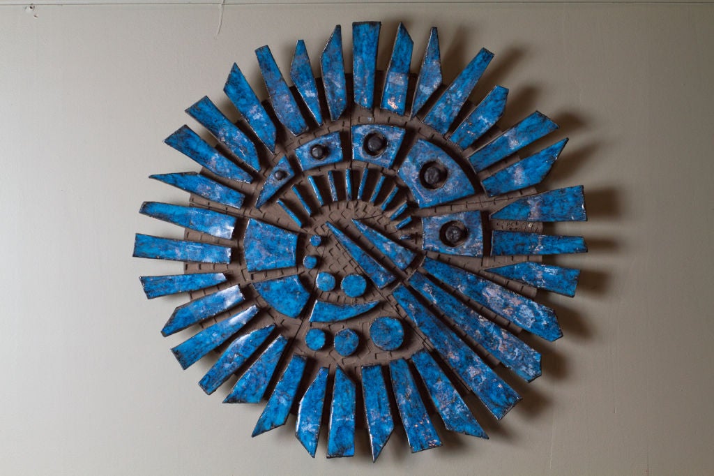 Vibrant blue glazed ceramic wall sculpture by Charles Sucsan.   

Sucsan was born in France to Hungarian parents. He studied art in Paria before moving to Montreal in 1952. He created murals during the 60s and 70s, which appear amongst other