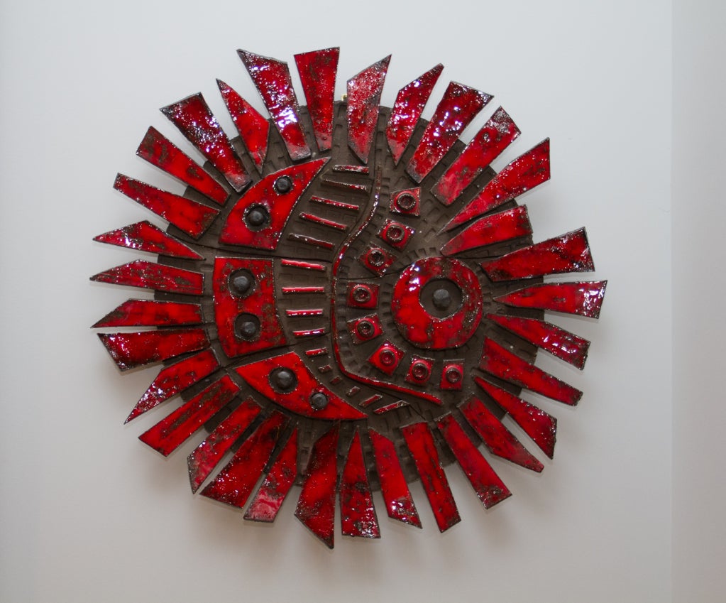 Vibrant red glazed ceramic wall sculpture by Charles Sucsan. 

Sucsan was born in France to Hungarian parents. He studied art in Paria before moving to Montreal in 1952. He created murals during the 60s and 70s, which appear amongst other places