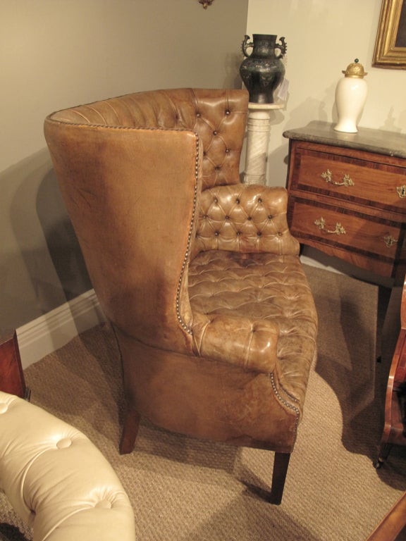 George III style wing back tufted leather settee on mahogany square tapered legs .
