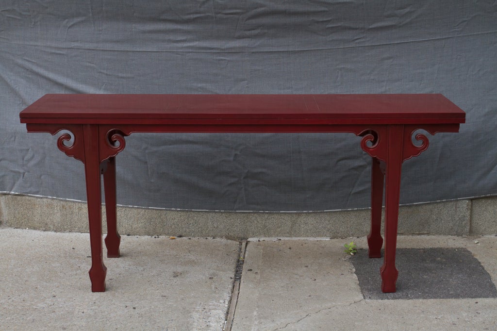 Interesting cinabar red Asian  Modern side table that converts into a dining table for six people, very useful for a small appartement or as a serving table in a large diningroom.Signed Baker Furniture.