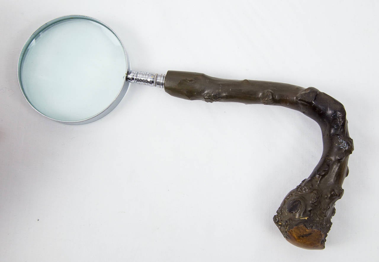 Unique desk or tabletop hand magnifying glass featuring a large round looking glass mounted to a fabulous burl wood handle, circa 1950s. A strange and wonderful deformity! Total length: 9.5”; glass diameter: 3”.
