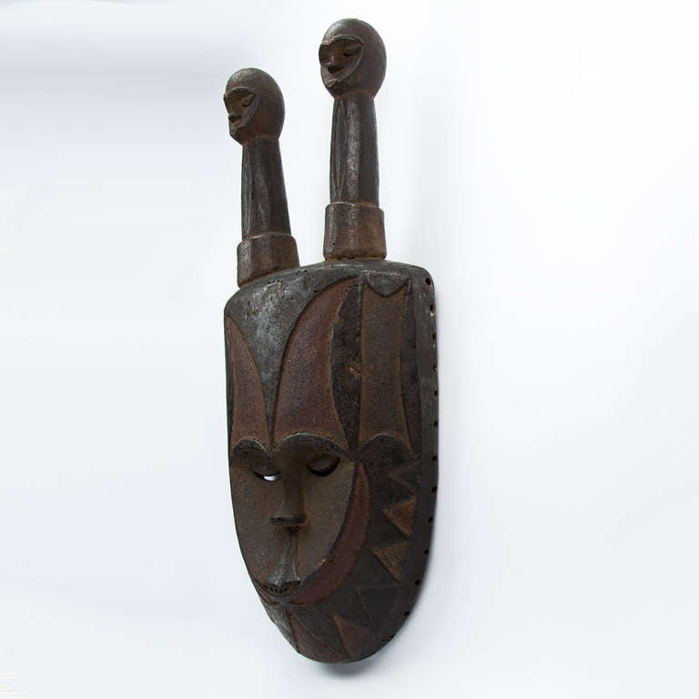 Among the Eket, a subgroup of the Ibibio, this type of headdress is worn by a dancer who wears a long white robe, with bells attached to the neck and a basket covered with rows of bells affixed to the lower back. The masks are used in the Ogbom