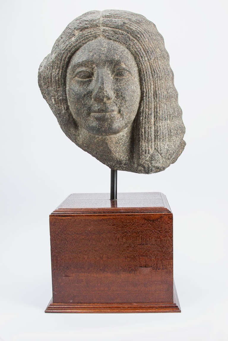Magnificent Basalt Head of Psammetique, his oval face with smooth cheeks tapering to his rounded chin, with wide, thin almond-shaped eyes, a sculpted nose and delicate full lips, framed by a magnificent head of hair. Beautifully executed! Approx.