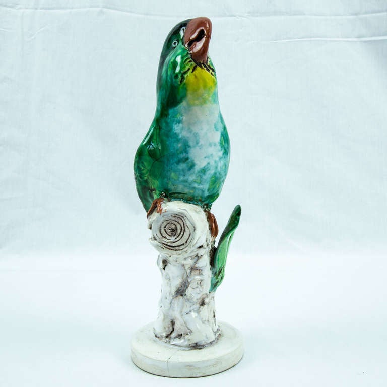 Beautiful parrot standing on tree stumps with foliage; intensely colored glazed pottery with fine detail and great graduated colors, clean and brilliant! Signed; circa 1930s. Measures: 10.5 inches high.