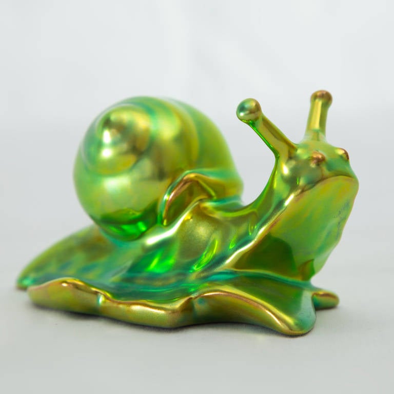 A Delightful Hand-Painted Iridescent Green Eosin Glaze Zsolnay Pécs Porcelain Figurine, depicting a Snail; Marked: 