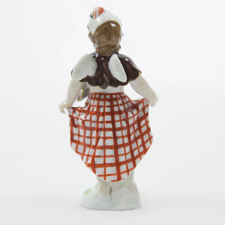 Delightful little Meissen porcelain figurine of a cherub as a Scottish lass, curtsying for a dance. From the tam atop her head to her plaid kilt to her little bare feet, she is a rosy-cheeked beauty.
Meissen crossed swords to reverse; circa