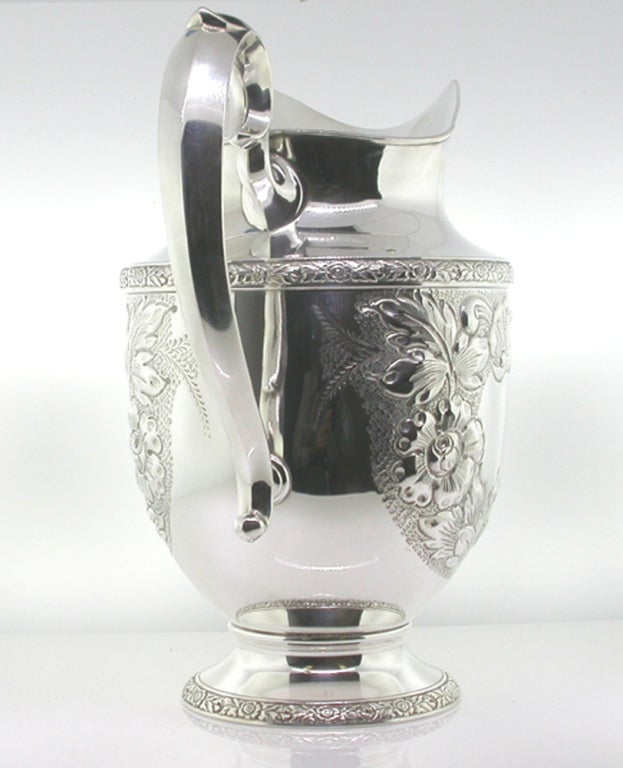 Sterling Silver Water Pitcher by Fisher, Beautifully decorated in high relief Repoussé displaying great detail of floral, foliate and shell elements  
Marked on base: FISHER STERLING 2037 “Rose Bouquet” HAND CHASED plus Fisher Hallmark/trademark.
