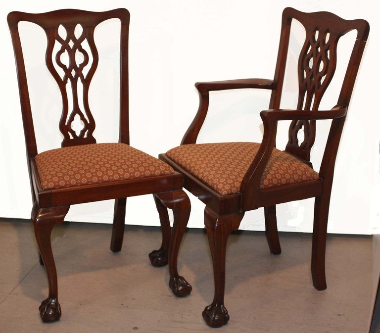 Set of six Chippendale style mahogany chairs and two armchairs with pierced splats on drop in seats, the front cabriole legs terminating in claw and ball feet.