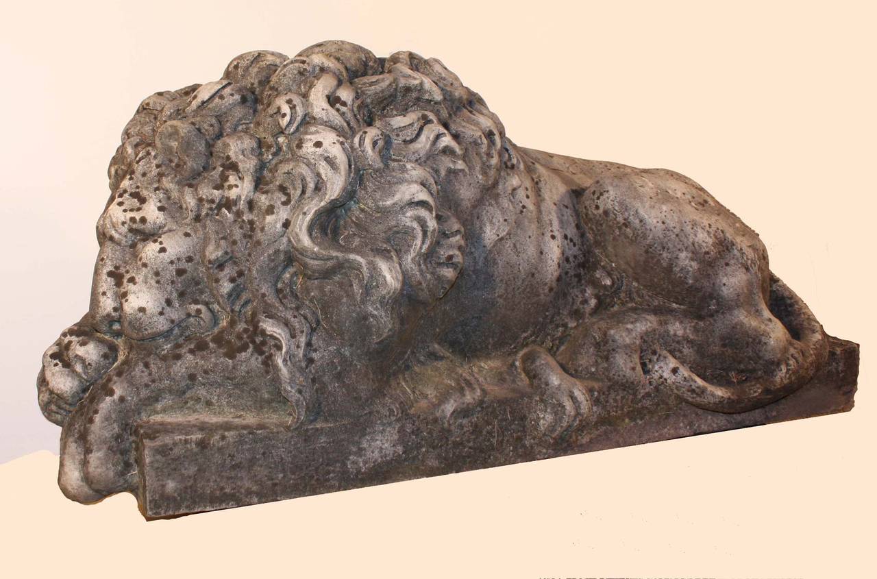 A fine pair of antique Italian carved marble recumbent lions. The originals, famous guardians of the tomb of Pope Clement XIII, were sculpted by Canova. They were much copied in various sizes from bookends to lifesize and often were bought by