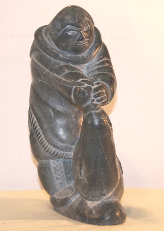 Inuit soapstone sculpture of hunter catching a seal.

Signed in syllabics and disc number, E.9.711.

Killupa Qingali, b.1934.