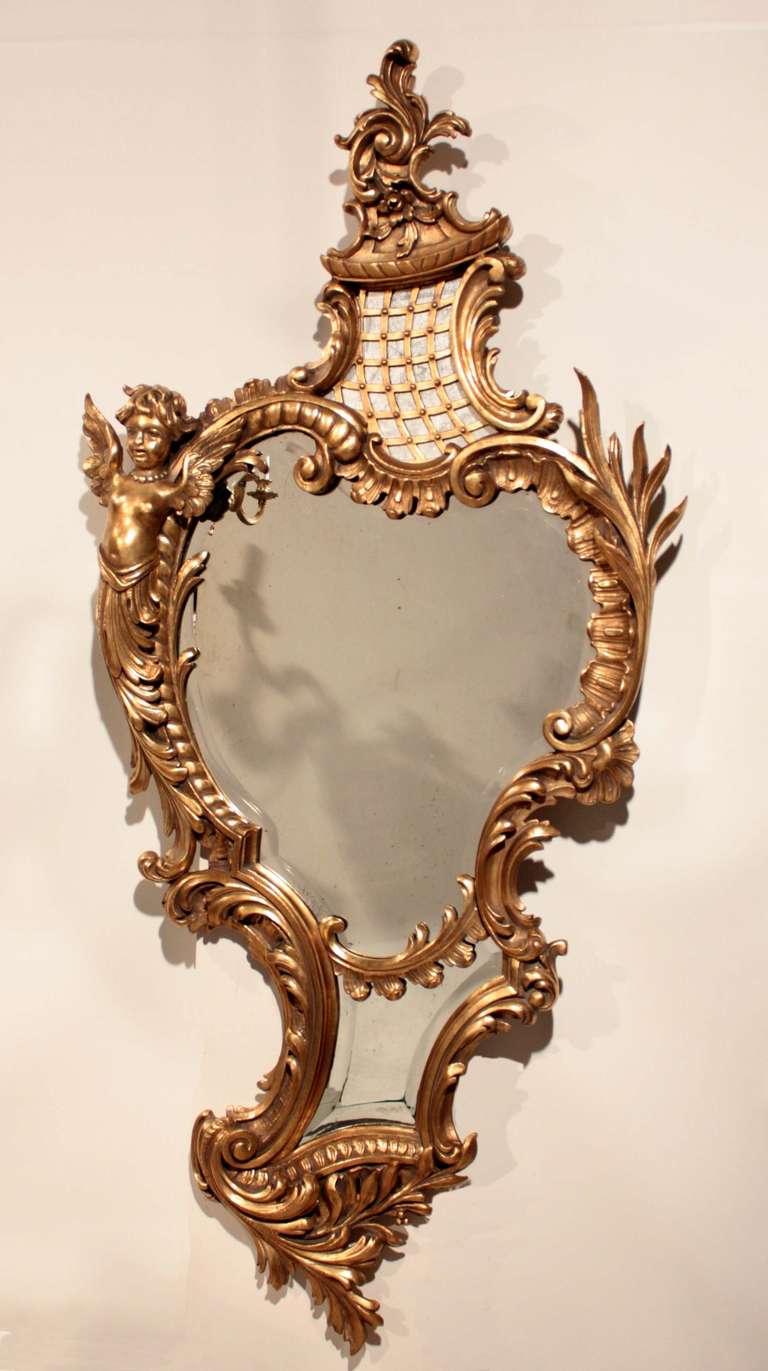 A 19th century Louis XV style triple panel  scrolling giltwood mirror. in the roccoco taste with scrolls winged maiden, and acanthus in an asymetrical frame