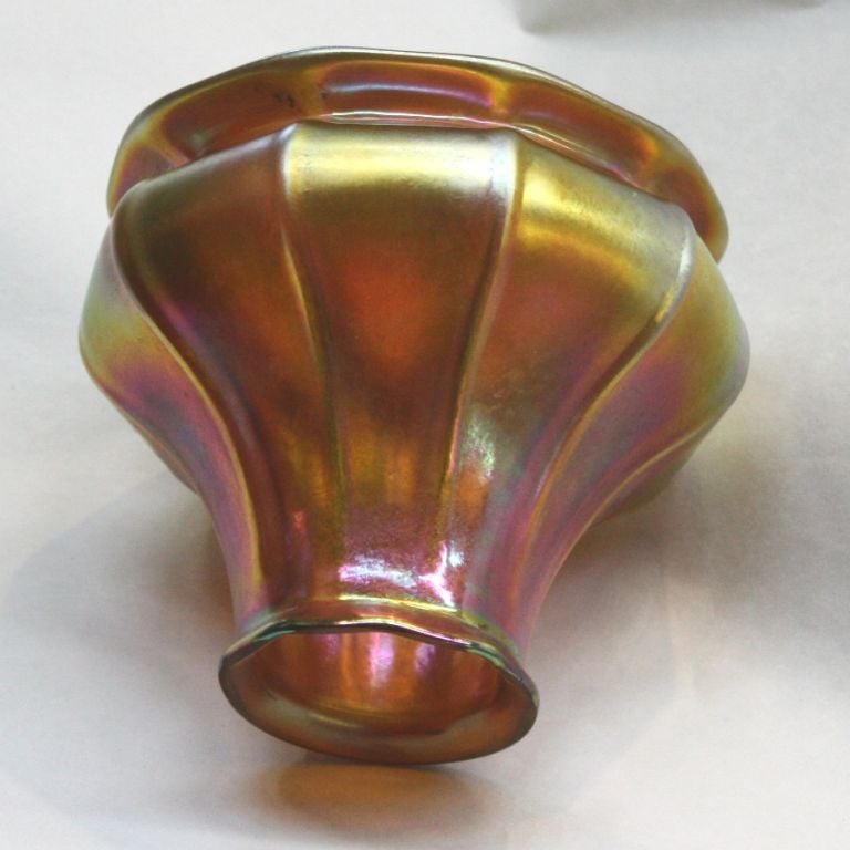 Hammered wrought iron cage with five loops suspending wrought iron chains and cups, with ribbed Steuben gold aurene shades (traces of Steuben mark).