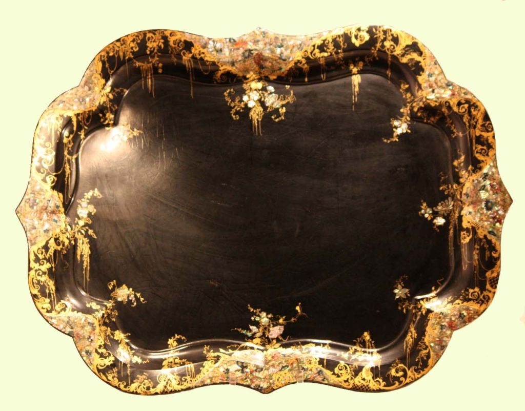 Graduated set of three Victorian papier mâché trays, with serpentine ogee borders, inlaid with mother'o pearl floral sprays and gilded, with scrollwork edging. Trays measure 31