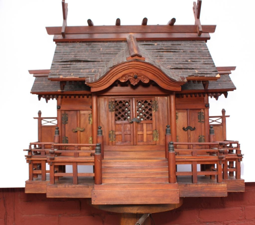 Meiji period three-door domestic Shinto shrine (kamidana) atop stairs leading to verandah and central double doors flanked by side doors, all fitted with bronze hardware; roof of cherry bark.