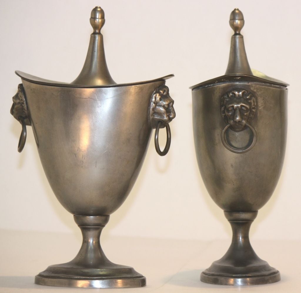 Pair of pewter lidded chestnut urns of ovoid form on waisted base over oval feet, and having lion's mask ring handles. Touchmark of Justus Johannes van Maurik (IVM and angel within circle).