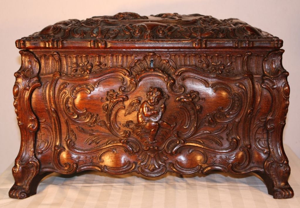 Symphonion #25C Rococo music box in simulated walnut case carved overall with puttis and dancing couple in foliate reserves, opening to crank operated player fitting 113/4