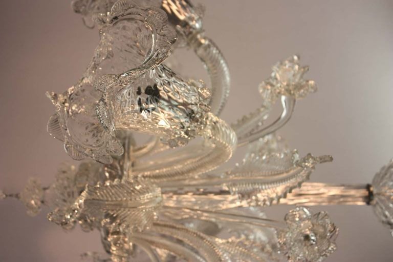 Mid century Murano clear glass six light chandelier fitted with cross hatched floral shape shades on curved stems with daffodils and cascading leaves  issuing from from central dish, over acorn form finial.