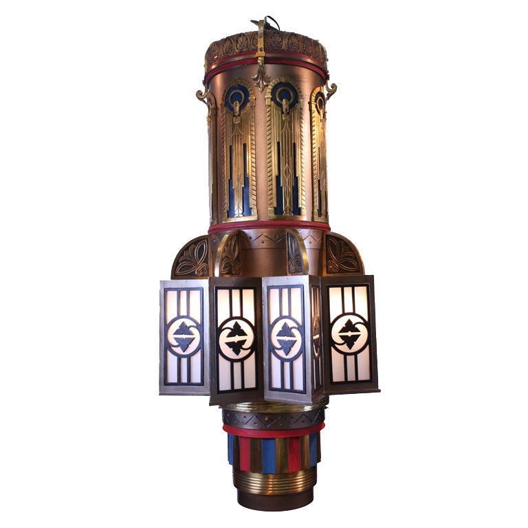 Art Deco brass and polychrome metal columnar ceiling pendant fixture with eight star-point metal overlaid frosted glass lights and two interior lights and 8 lights in the side panals. Three available.