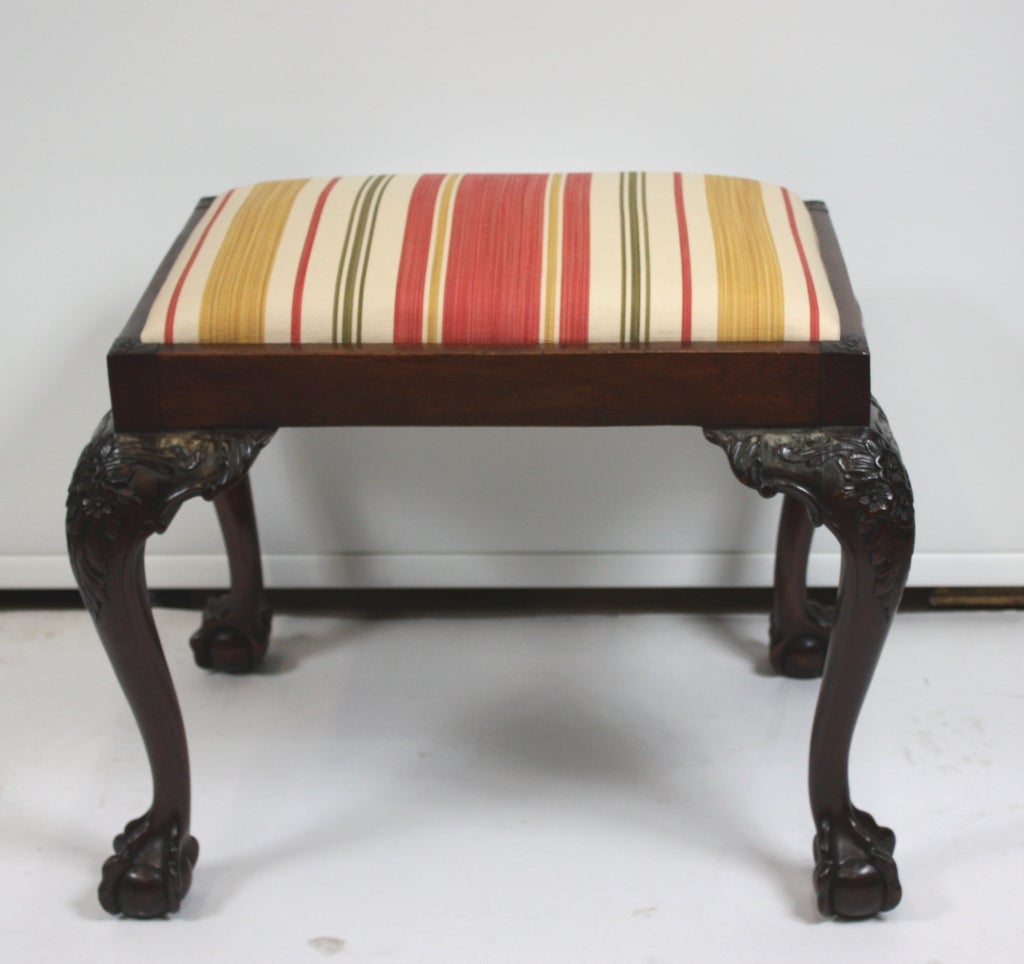 This Chippendale style mahogany stool is well carved  at the knee and with cabriole legs and ball and claw feet. The recently recovered drop-in seat can be readily changed to the fabric of your choice