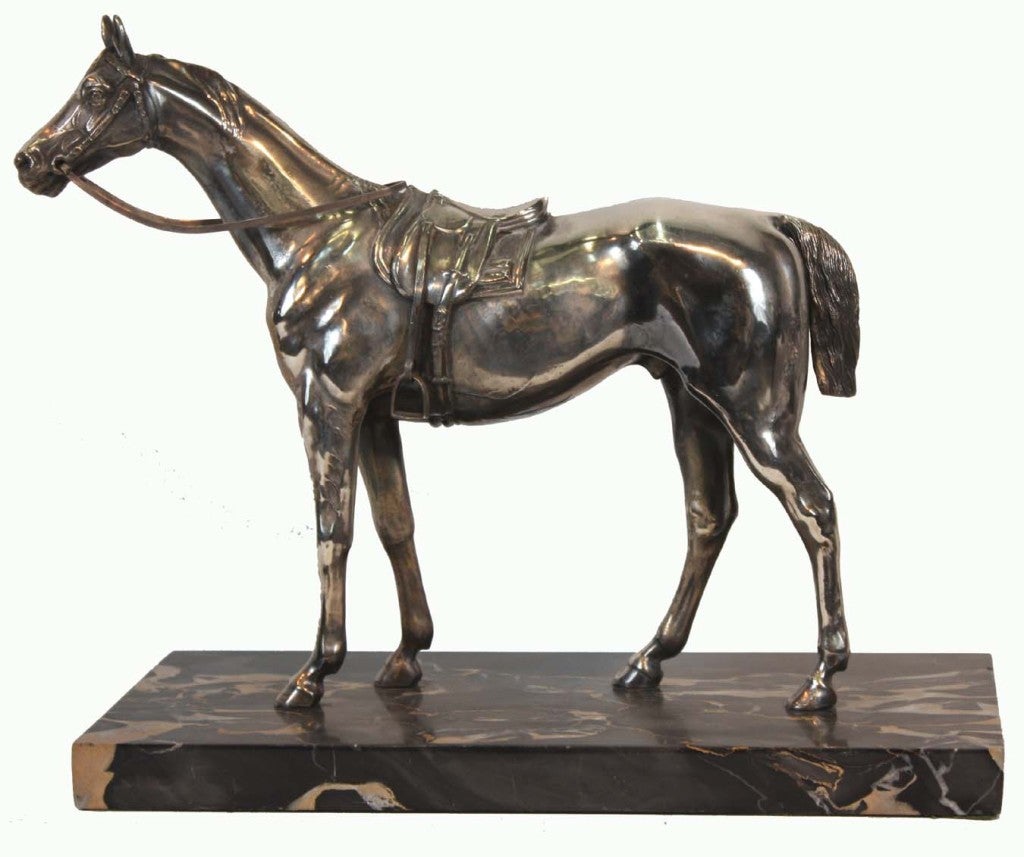 Silvered metal saddled horse on marble base.